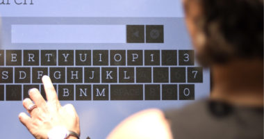 fingers typing on a touchscreen directory