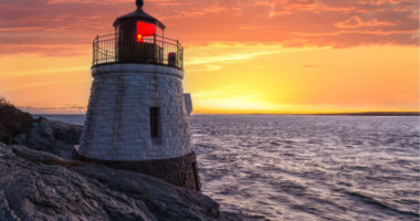 lighthouse on cliff at sunset